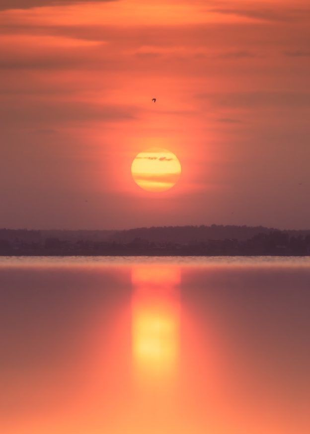 Warm sunset over a calm body of water.